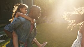 Man playing with kids in backyard wondering how much life insurance he needs.