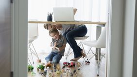 Mom working from home with a child nearby.