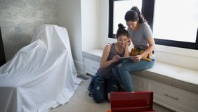 Mother and daughter work on a home DIY project.