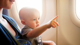 baby on plane pointing