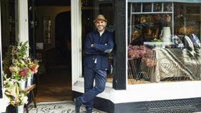 Man standing int front of his furniture store. 