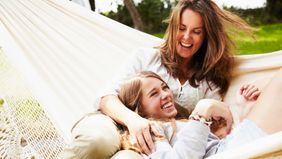 mother and daughter relaxing in hammock on vacation