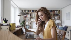 Woman in a home office taking financial steps before starting her business.