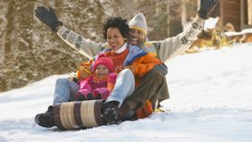Family sledding together on a winter getaway.