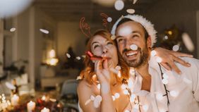 Couple celebrating New Year’s together with lights hoping to achieve money resolutions. 