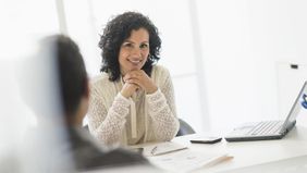 Woman sitting at a desk thinking about her passive job search