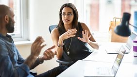  Man and woman at table discussing manager holding you back