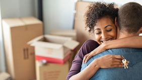 woman hugging man while holding home keys