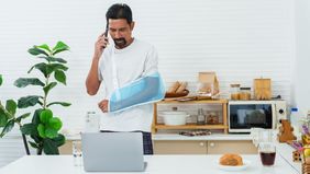 Man at home with injured arm