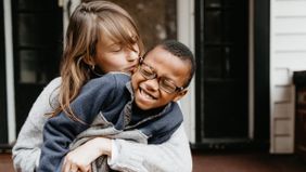 Mom holding and kissing her son as she is thinking about opening an UTMA account 