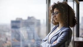Woman thinking about Northwestern Mutual’s weekly market commentary.