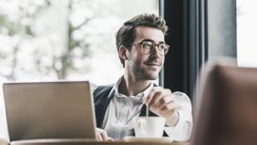 Man looking out window after reading Northwestern Mutual’s weekly market commentary.