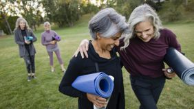 retired women walking with yoga mats