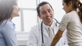 Woman and daughter learning from a doctor what a health insurance deductible is