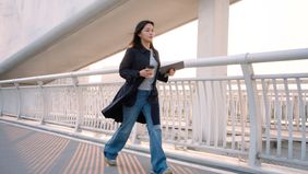 Female walks while having coffee in the city