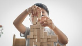 A boy playing with toy blocks.