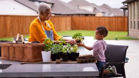 Grandmother gardening with her grandson