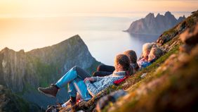 women watching a sunset on a mountain