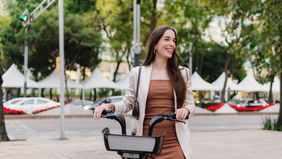 A young woman with straight hair on the street using a bicycle