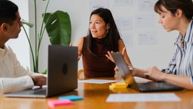 Financial professionals conduct team meeting in sunlit office