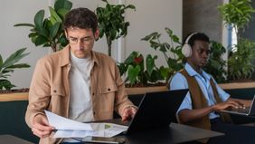 Colleagues working side-by-side on their computers.