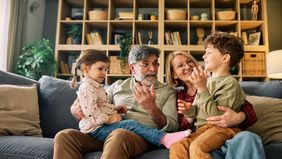 Grandparents talking with grandchildren on sofa