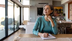 Woman brainstorms financial strategy with pen and paper