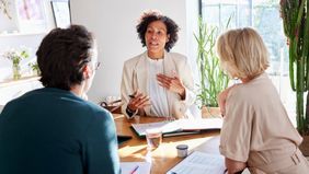 Financial advisor meeting with couple at table in modern home