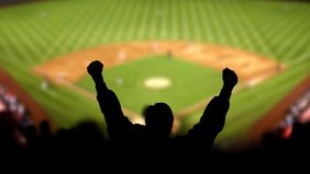 Fans lifting hands in celebration at a baseball game
