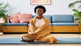 A woman meditating with a blanket