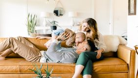 Couple relaxing on a sofa with baby