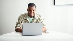 Man reading Northwestern Mutual Wealth Management Company’s weekly market commentary on laptop 