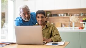 Couple checking commentary in kitchen