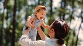 woman playing with baby