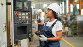 Woman working in a factory wondering how tariffs will impact her job and the economy.