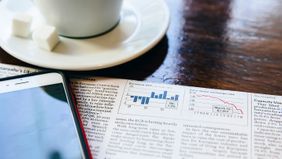 Coffee, smartphone and financial newspaper on a table