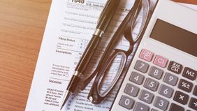 Tax form, glasses and calculator