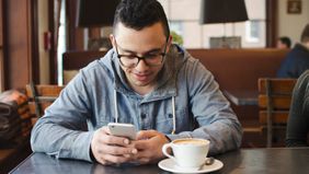 man in coffee shop on his phone