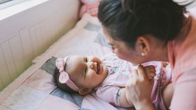 Mother and baby on bed