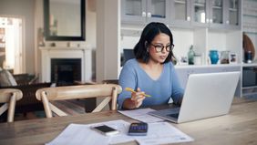 Woman working on her finances on a laptop.