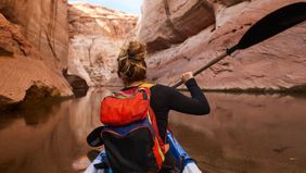Woman kayaking and enjoying her financial freedom by maintaining a diversified portfolio with Northwestern Mutual Wealth Management Company