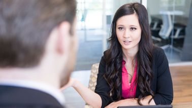 Coworkers in an office discussing how to ask for a raise