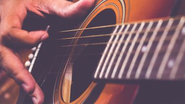Man playing guitar after investing