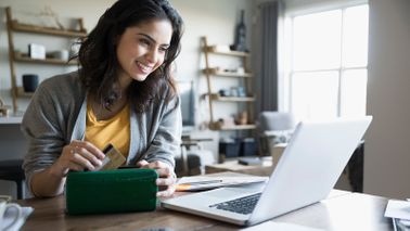 Woman on computer getting the most of her travel miles and points