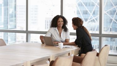 Two women discussing tips for giving critical feedback at work