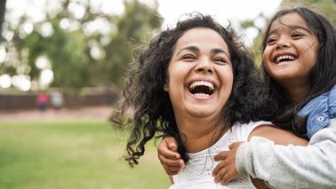 Happy mother having fun with her daughter outdoors