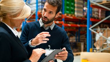 Man and woman discussing inventory and tariffs.