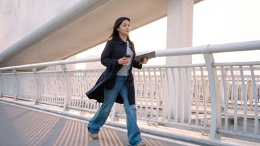 Female walks while having coffee in the city