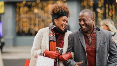 Happy couple enjoying winter holiday shopping thanks to their solid financial plan with a Northwestern Mutual advisor.