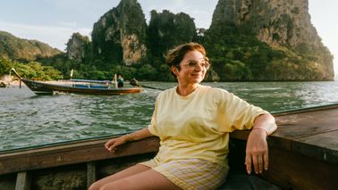 woman smiling and enjoying a boat ride on a solo trip
